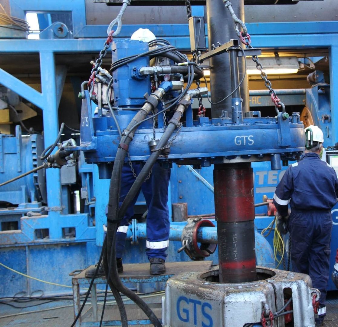 A man works on a large machine in an industrial setting.