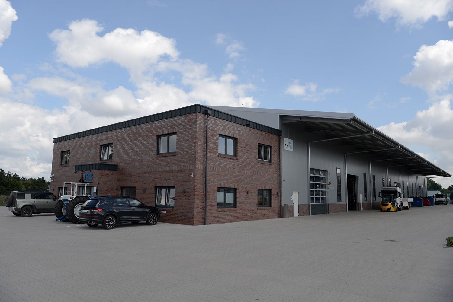 A large company building with cars parked in front of it
